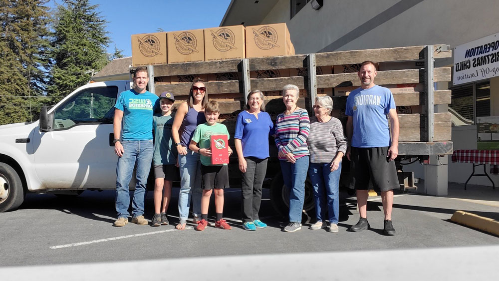 Group standing in front of truck carrying Operation Christmas Child shipment